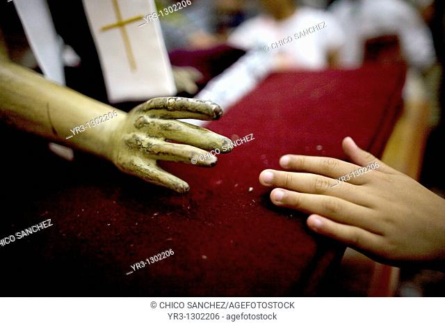 A woman touches the hand of a statue of Jesus Christ during holy week celebrations in Oaxaca, Mexico, April 10, 2009
