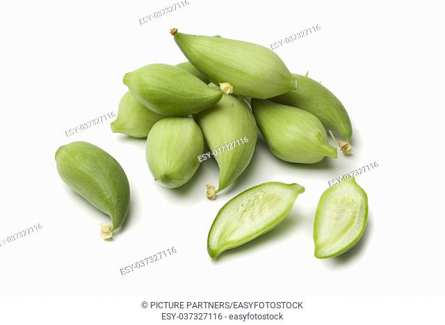 Whole and half green heirloom wild cucumbers on white background