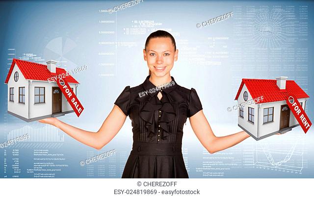 Businesswoman holding two house with tags for sale and rent. Hi-tech graphs as backdrop. Business concept
