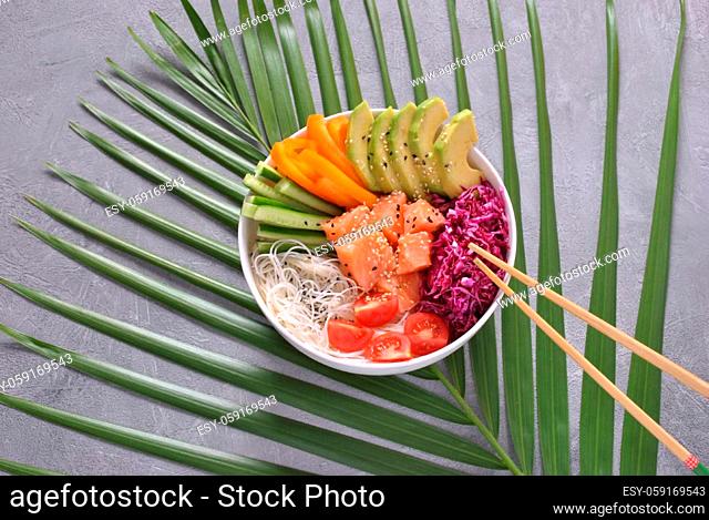 Fresh seafood recipe. Organic food. Fresh salmon poke bowl with crystal noodles, fresh red cabbage, avocado, cherry tomatoes. Food concept poke bow
