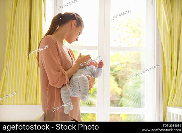 Mother Bottle Feeding Baby in Nursery
