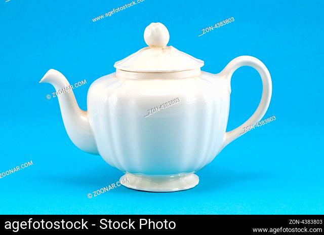 retro ceramic white teapot dish on blue background