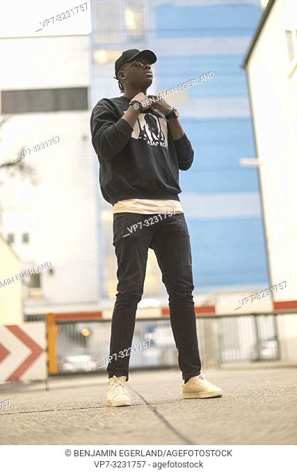 man wearing urban street style clothes, at industrial area in Munich, Germany