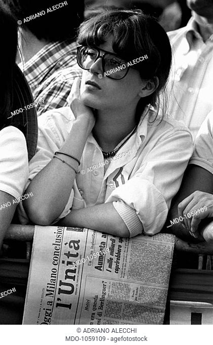 Festa dell'Unità. Girl with the newspaper of the Italian Communist Party l'Unità attending Festa dell'Unità in Parco Sempione. Milan, September 1979