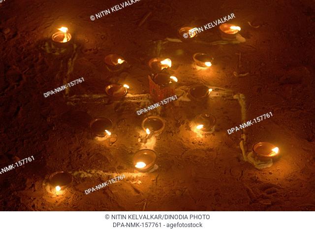 Illuminated Swastika lighting of lamps for celebrating Tripurari Purnima or Tripuri Poornima or Dev Diwali Deepostav at Mandapeshwar caves ; Borivali ; Bombay...
