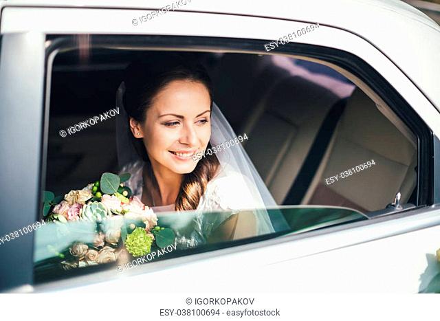 close-up portrait of a pretty bride in a car window white