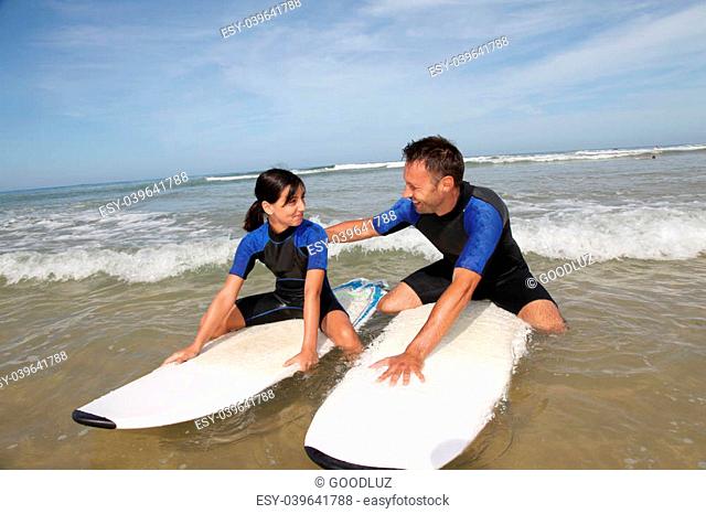 Father and daughter surfing in the ocean