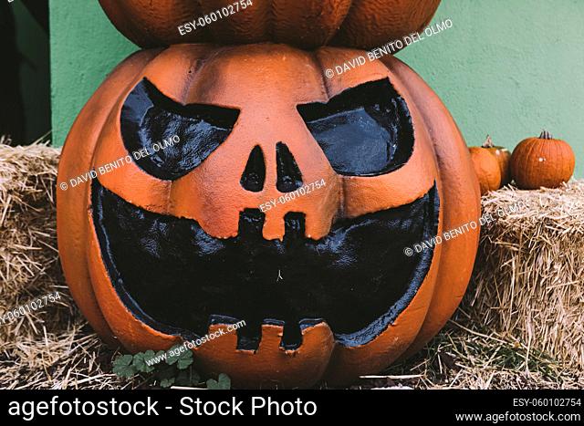 A Halloween decorative dark colored Jack-o-Lantern pumpkin on the street. Halloween and carnival celebration concept