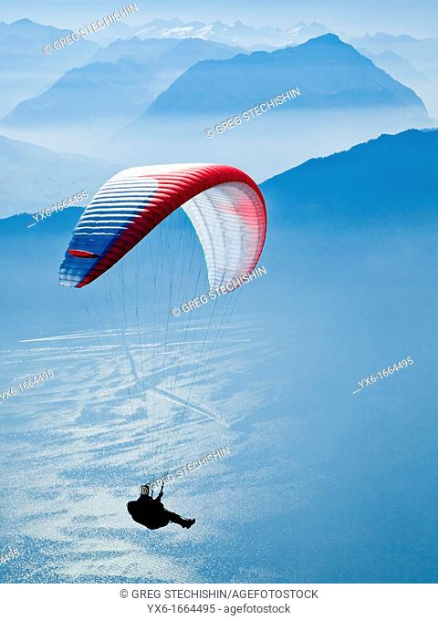 A man paragliding in the Swiss Alps near Mount Rigi