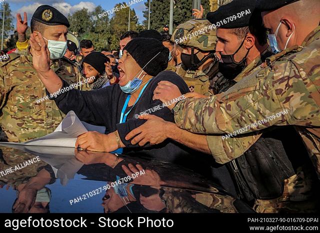 27 March 2021, Lebanon, Baabda: An anti-government protester shouts slogans as Lebanese soldiers block a highway leading to the Presidential palace in Baabda...