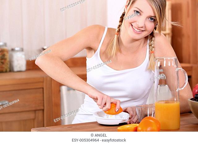 A blond pressing oranges