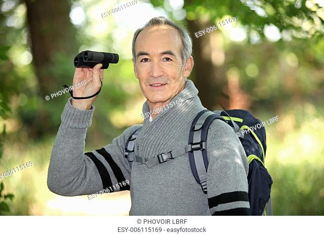 Grey haired man with binoculars
