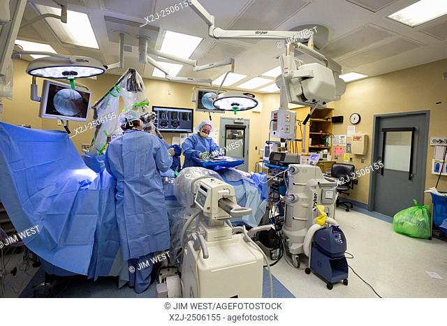 Englewood, Colorado - Dr. Paul Elliott (back to camera) performs minimally invasive lumbar spine surgery on a patient at Swedish Medical Center