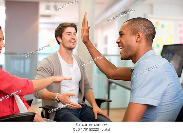 Business people high fiving in meeting