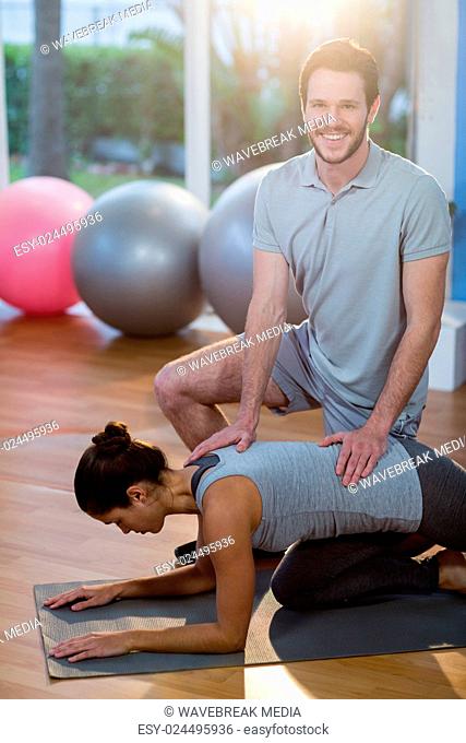 Physiotherapist assisting a female patient while exercising