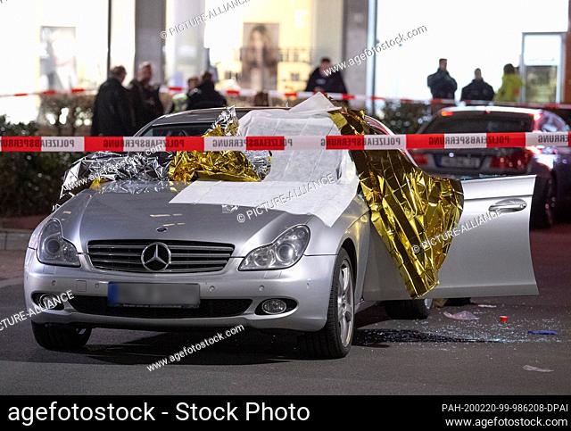 20 February 2020, Hessen, Hanau: A Mercedes is covered with foil in front of a bar in Hanau-Kesselstadt after shots were fired