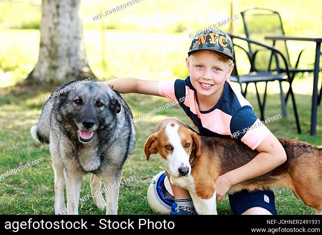 Smiling boy with dogs looking at camera