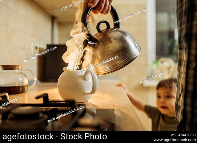Man pouring hot water in tea pot