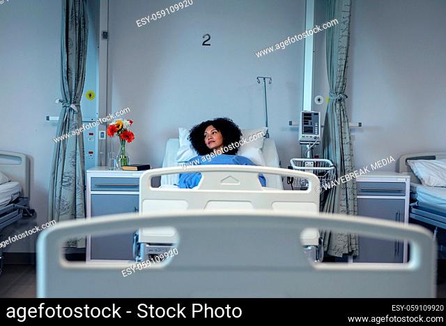 Thoughtful african american female patient lying in hospital bed looking to side