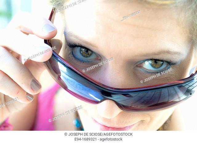 41 year old blond woman looking over her sun glasses
