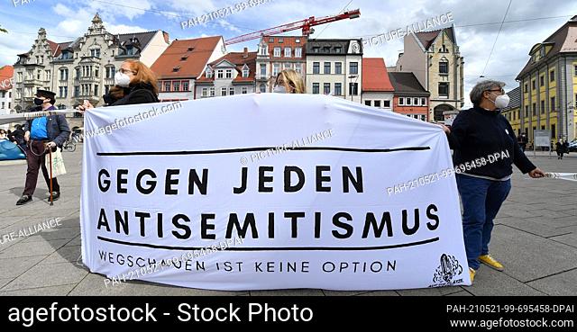 21 May 2021, Thuringia, Erfurt: A banner with the inscription ""Against all anti-Semitism. Looking away is not an option"" is held by citizens at a rally on the...