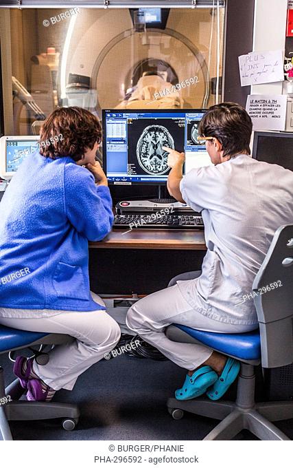 Doctors monitore a patient undergoing a Computed Tomography (CT) scan of the brain, Bordeaux hospital, France