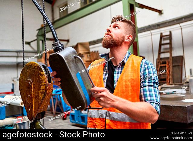 Arbeiter am Bedienfeld einer Koordinatenbohrmaschine in der Werkstatt einer Fabrik