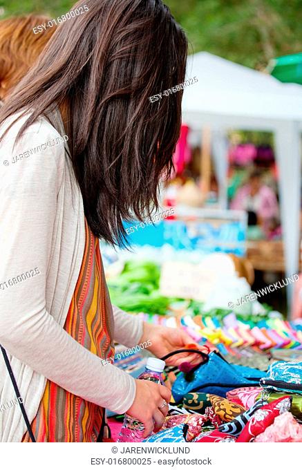 Biracial teen girl shopping at outdoor bazaar market in Thailand