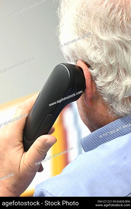 29 December 2022, Bavaria, Munich: An employee sits in the Catholic Telephone Counseling Center in the state capital and holds a telephone receiver to his ear