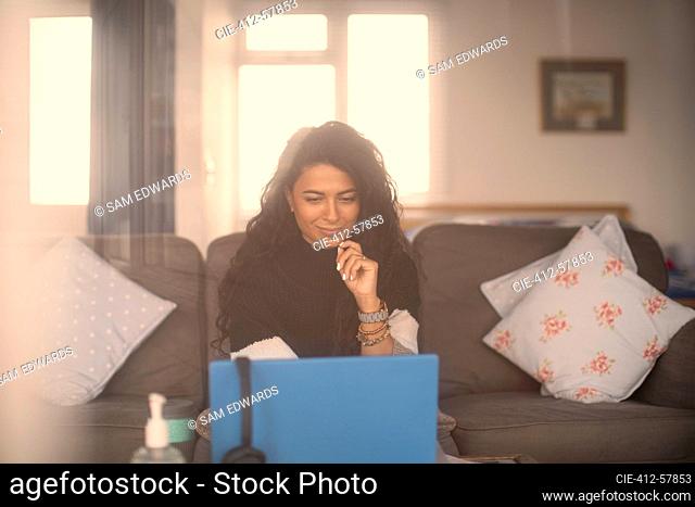 Woman working from home at laptop in living room