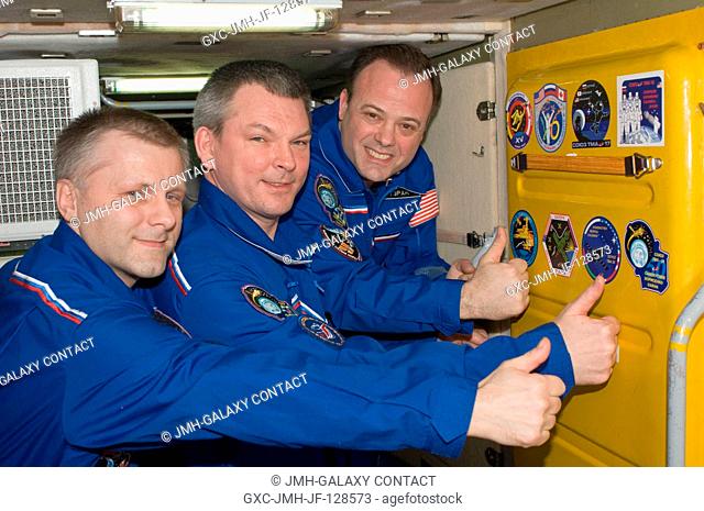 In the Zarya Functional Cargo Block (FGB), Expedition 28 crew members add the Soyuz TMA-21 patch to the growing collection of insignias representing crews who...