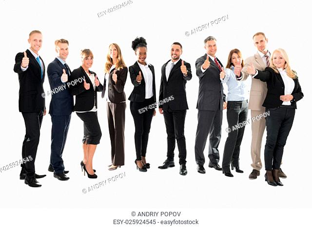 Full length portrait of business team showing thumbs up against white background