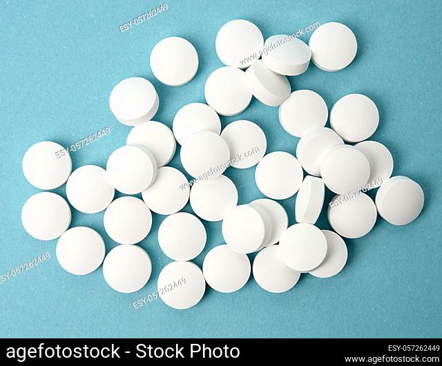 White round pill for healthcare. Medical treatment, blue background, top view