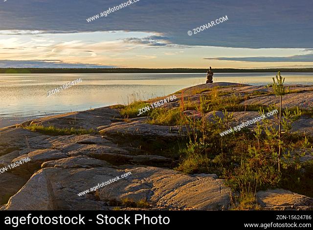 Evening on the White Sea. Stone pillar on coastal granite rock. Kandalaksha Gulf, Karelia, Russia, end of June