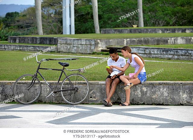 Teenagers using mobile phone in Che Guevara square, Santa Clara, Cuba