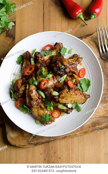 Barbecue chicken wings topped with chilli peppers