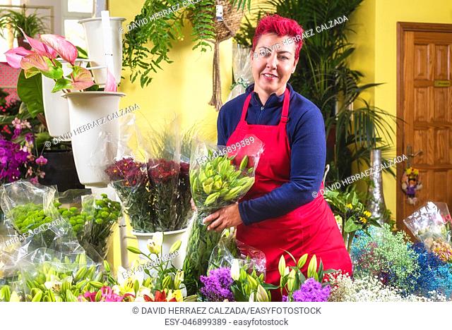 Happy woman florist, making arrangements, and smiling at camera. small business Flower shop owner