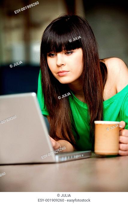 Girl with a cup near the computer