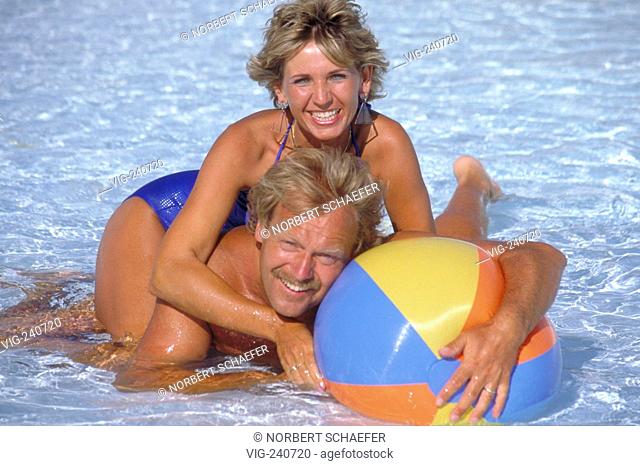 portrait, blond couple, ca. 35 years, is having fun in the flat water of a swimmingpool with a coloured waterball  - 0, GERMANY, 08/10/2002