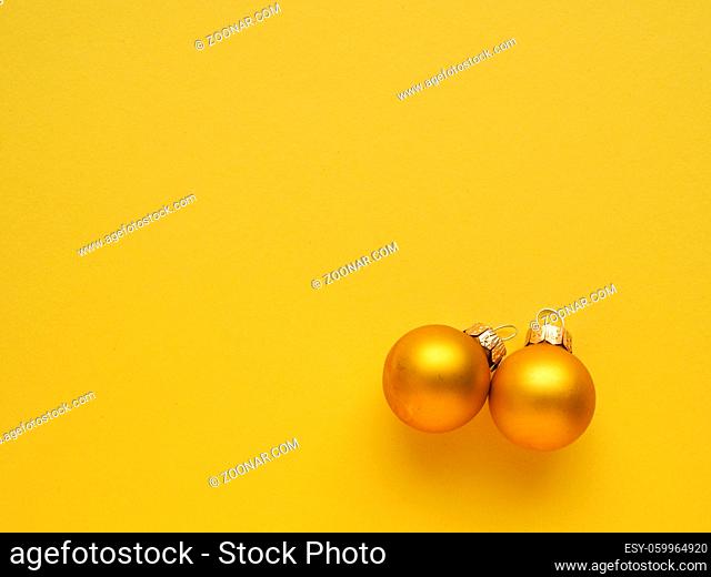 Golden vintage Christmas baubles on a yellow background with space for your text or image, seasonal holiday concept