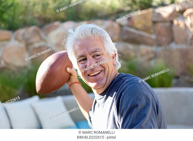 Caucasian man throwing football