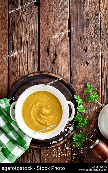 Vegetable cream soup, puree on wooden rustic table, top view