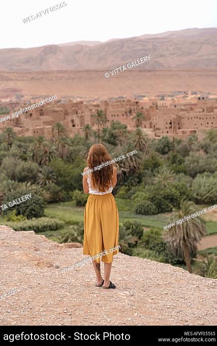 Back view of young woman looking at the city, Ouarzazate, Morocco