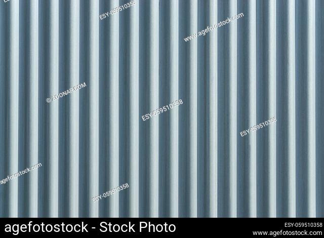 Closeup stainless steel corrugated sheet. Ridged reinforced metal surface for protection. Metallic background texture