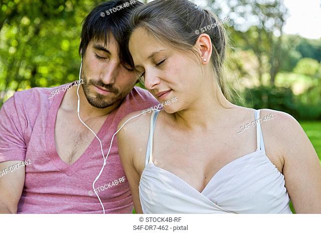 Man and woman listening to music with eyes closed