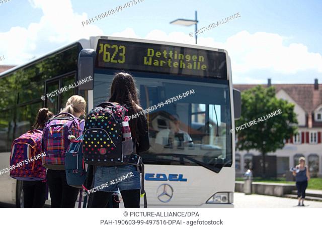 03 June 2019, Baden-Wuerttemberg, Rottenburg am Neckar: Schoolgirls are standing at a bus stop in the city centre. There's a bus in front of them