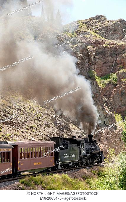 USA, New Mexico, Chama. The Cumbres and Toltec Scenic Railroad. Steam train climbs through rock canyon