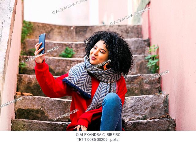 Mujer joven tomando selfie en escalera
