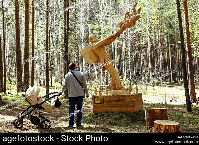 RUSSIA, IRKUTSK REGION - MAY 13, 2023: A visitor at the 10th Lukomorye Na Baikale international wood sculpture festival. As part of the festival