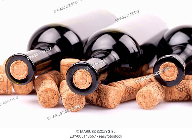 three closed wine bottles and corks
